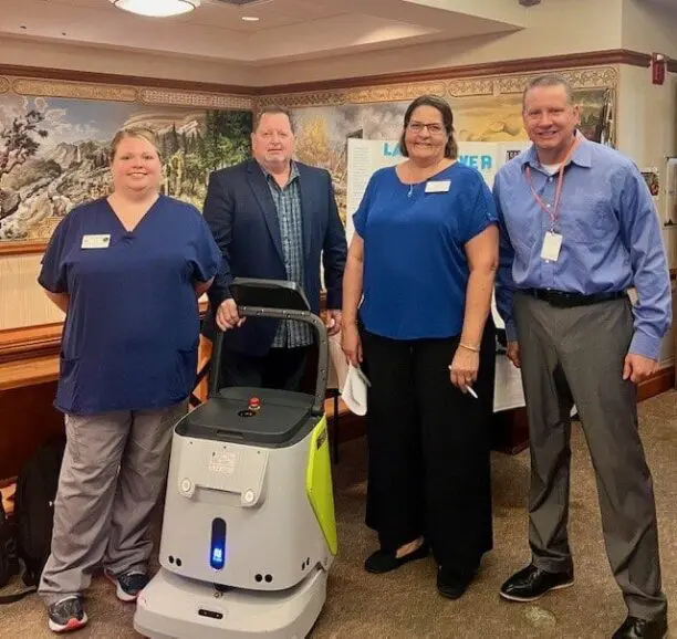 4 people with cleaning robot