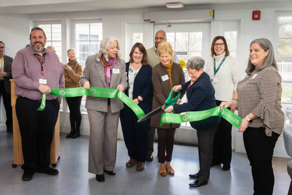Seven people cutting ribbon