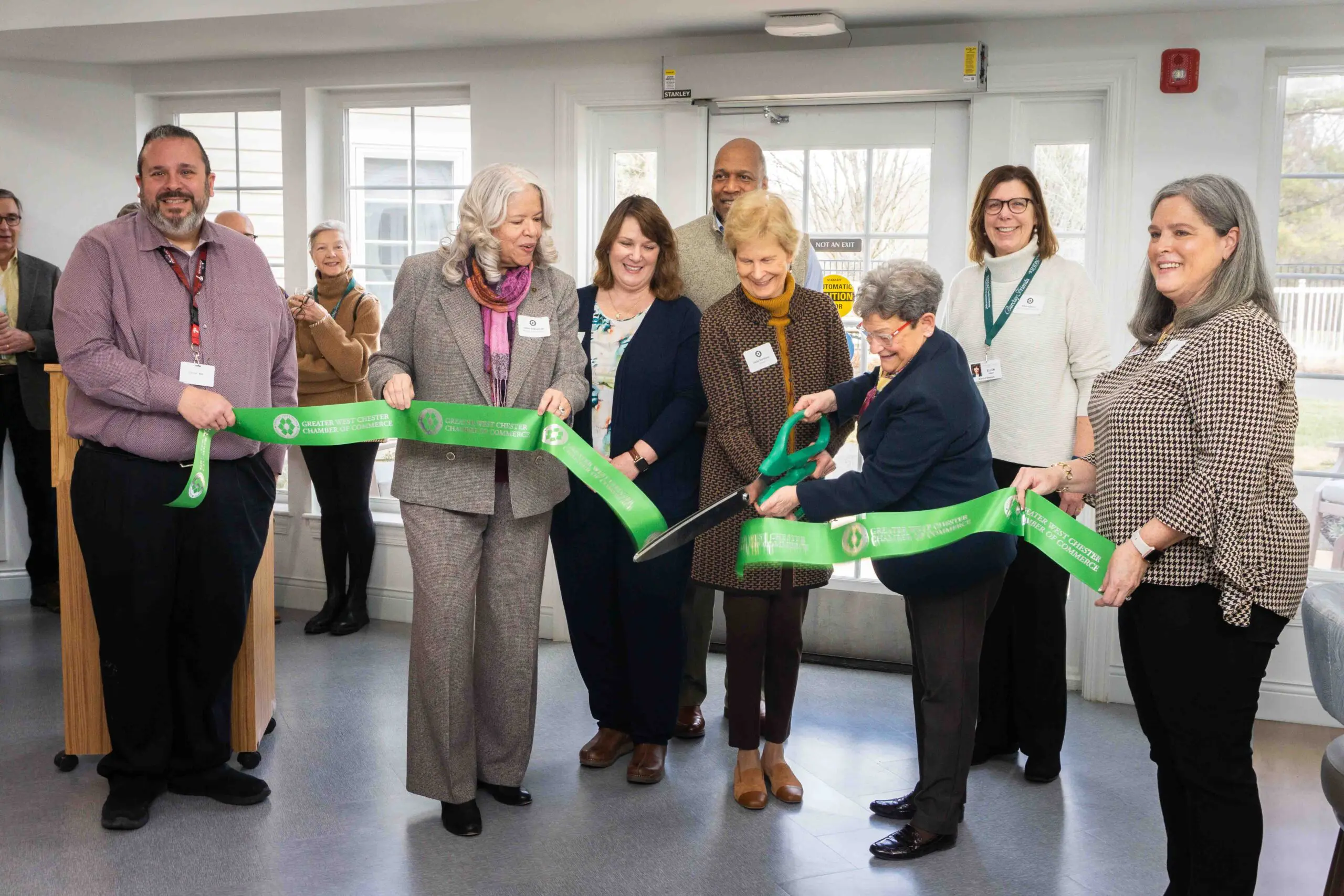 Seven people cutting ribbon