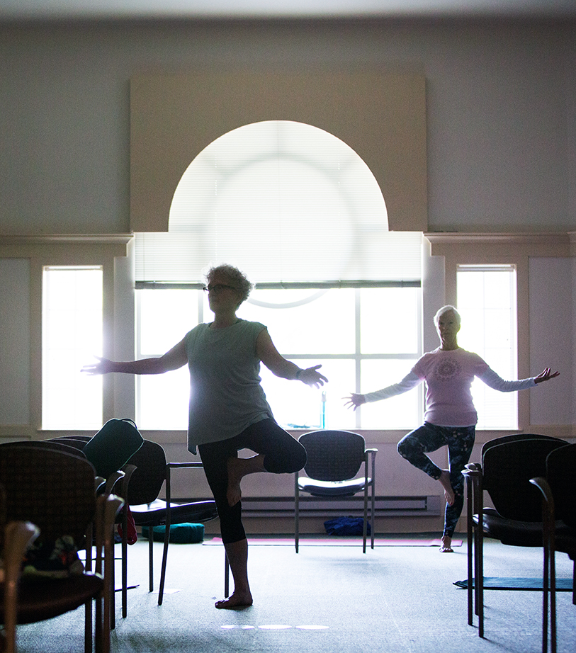 Senior women participate in yoga, a mindfulness activity at a retirement community
