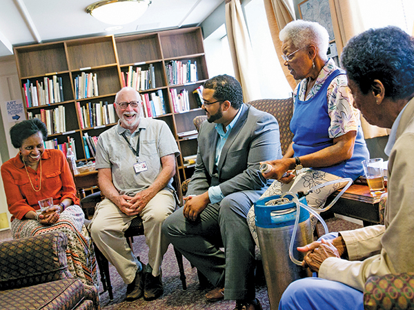 residents and staff gather in library