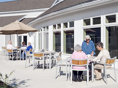 Residents on patio under umbrellas