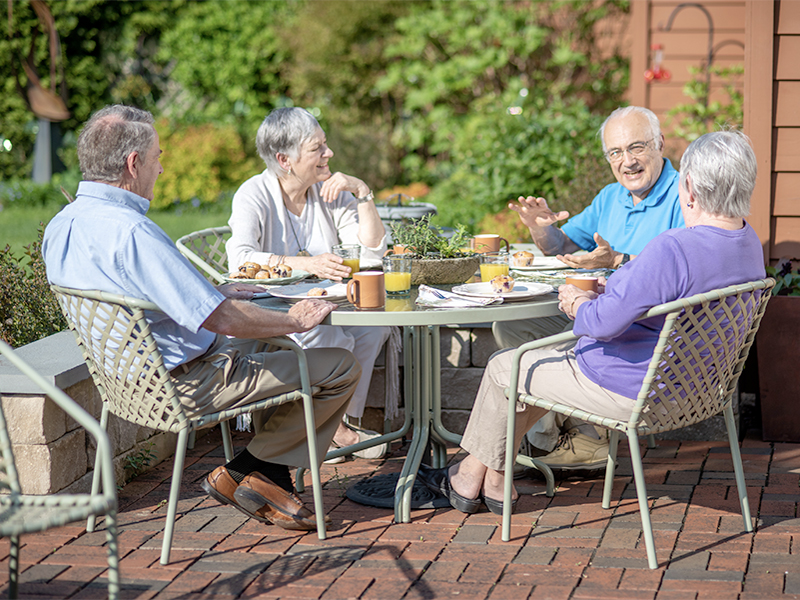 Two KCC couples conversing on patio