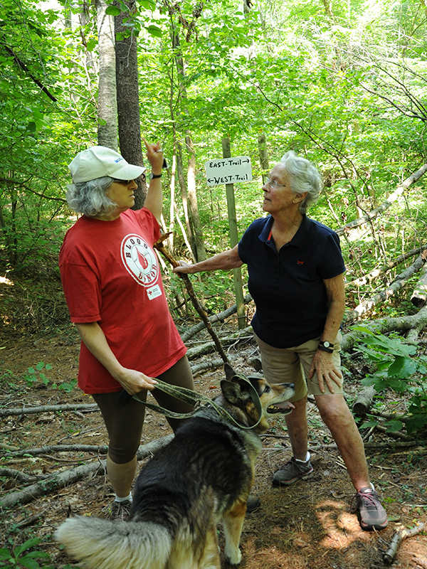 Lathrop residents and dog meet at junction of 2 trails in the woods