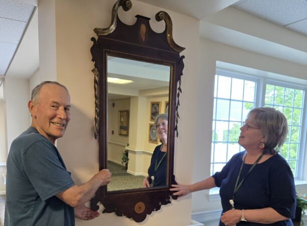 woman and man hanging mirror Kendal at Lexington