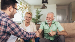 senior couple shaking hands with a representative after signing a contract