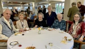 Seniors smile at table during Kendal on Hudson's 20th anniversary party
