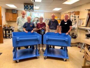 group of 5 residents standing around two blue carts